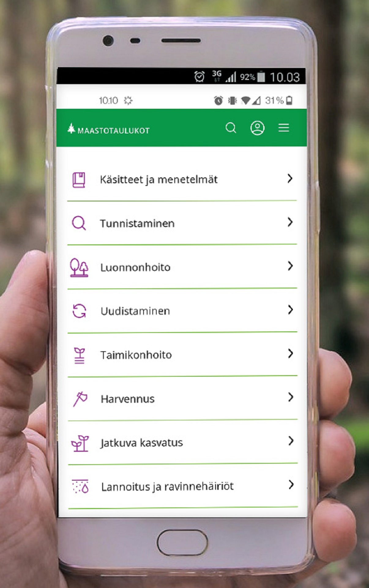Maastotaulukot-sovellus puhelimessa henkilön kädessä
